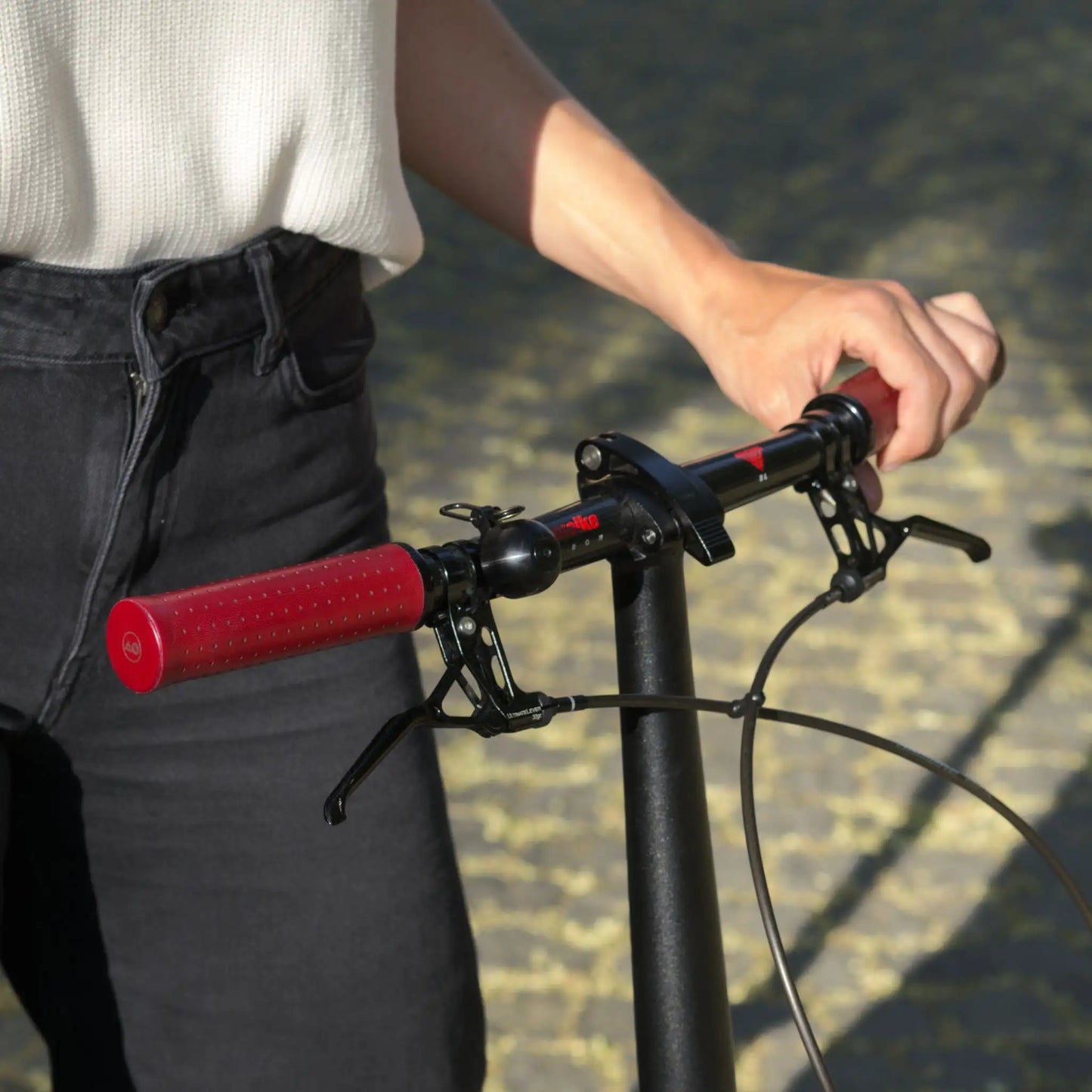 Fahrradgriffe LederRot (Bordeaux) mit schwarzem Klemmring an einem Brompton Faltrad mit Titanlenker – hochwertige, handgefertigte Ledergriffe für optimalen Grip und Langlebigkeit. Perfekt für anspruchsvolle Brompton-Fahrer, die Wert auf Stil, Komfort und Qualität legen.
