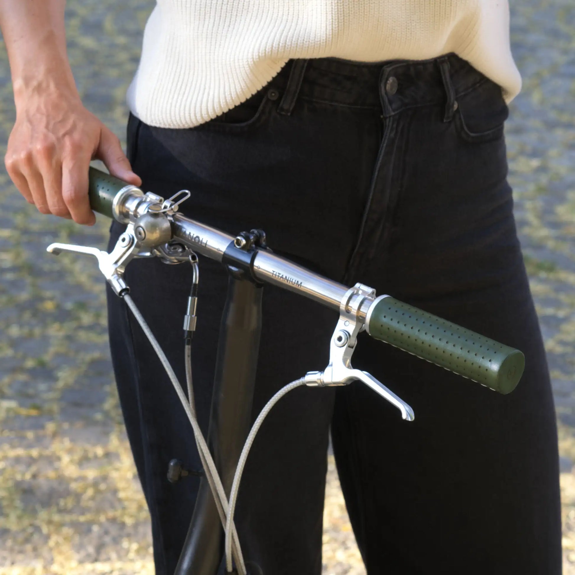 Fahrradgriffe Leder Grün (Cypressa) mit silbernem Klemmring an einem Brompton Faltrad mit Titanlenker – hochwertige, handgefertigte Ledergriffe für optimalen Grip und Langlebigkeit. Perfekt für anspruchsvolle Brompton-Fahrer, die Wert auf Stil, Komfort und Qualität legen.
