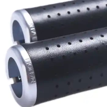 Manoli Ledergriffe mit präziser Laserperforation für bessere Belüftung und optimalen Grip, kombiniert mit CNC-gefrästen Aluminium-Klemmringen für sicheren Halt.